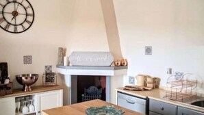 A kitchen with a wooden countertop, a decorative bowl, a clock, and a hanging light fixture. - Beautiful villa with scenic views, located between Ostuni & Cisternino. (Ostuni)