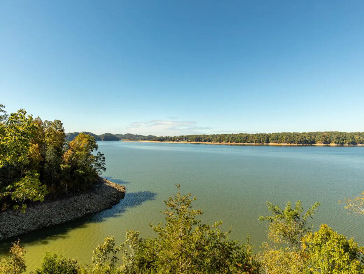 Un lac aux rives rocheuses et bordé d’une végétation dense.