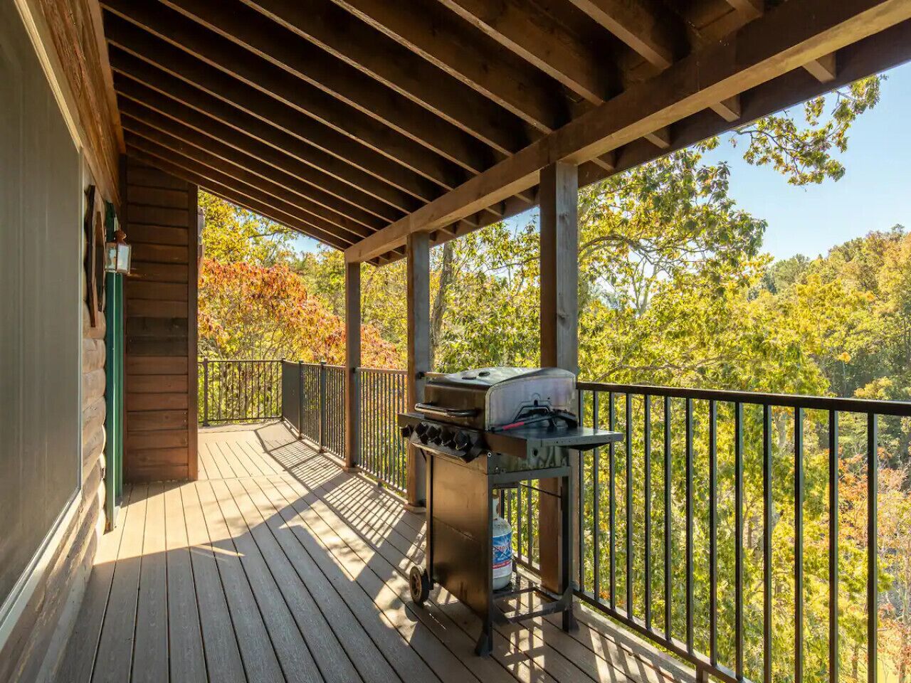 A wooden deck with a grill and a gas canister.