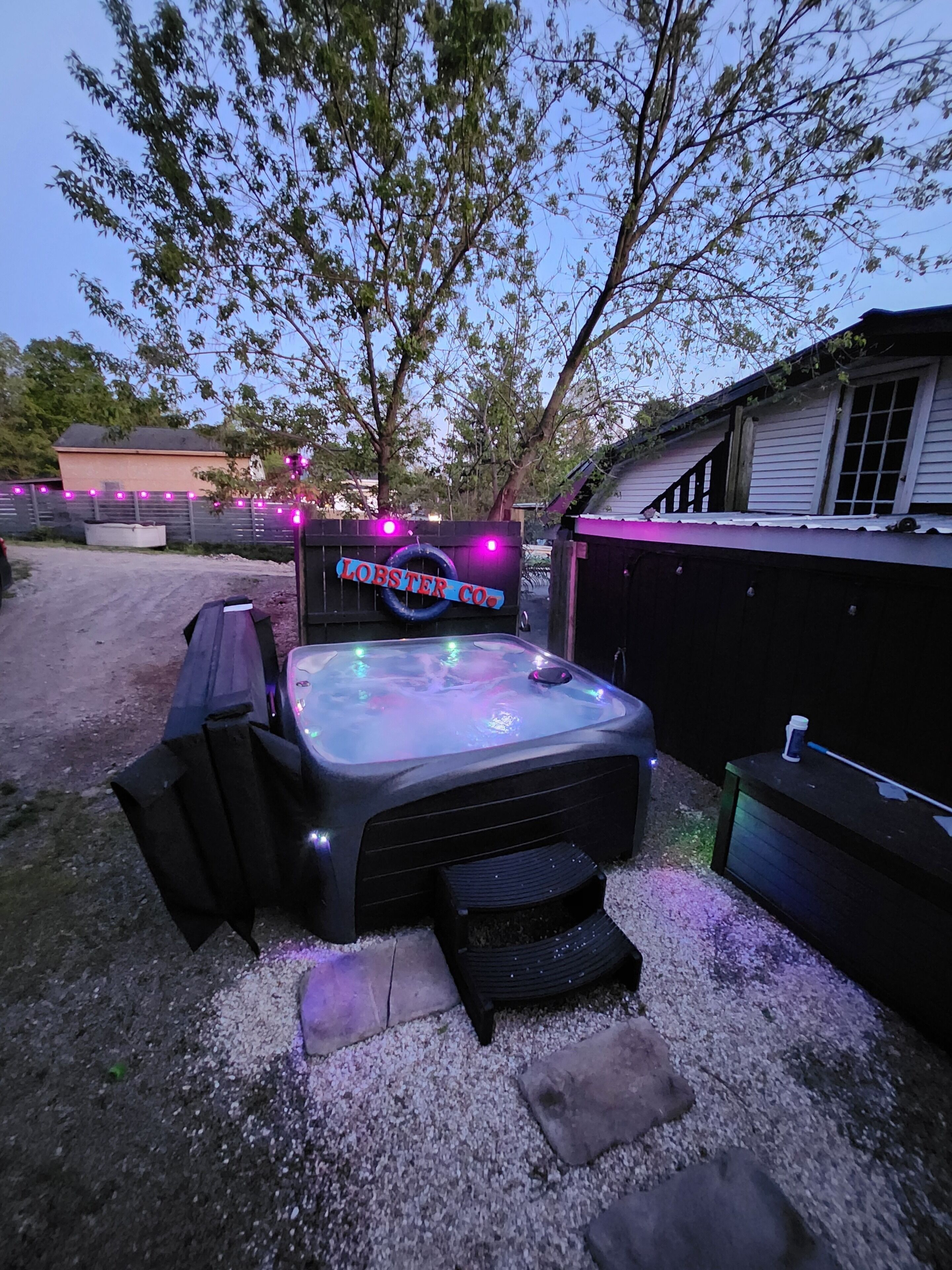 Un jacuzzi con un cartel que dice 'OYSTER CO.' en un patio trasero.
