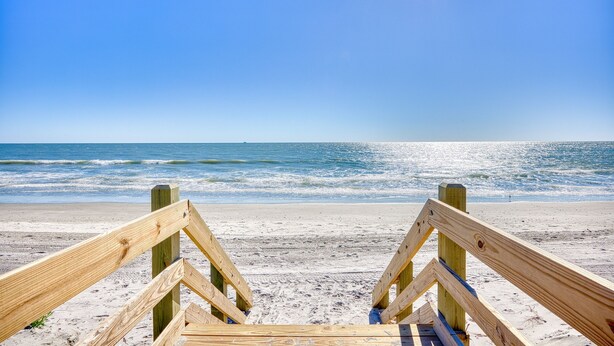 A wooden beach walkway leading to the ocean.