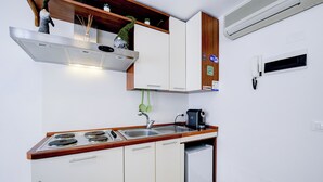 A compact kitchen with a stove, sink, and a small refrigerator.