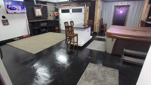 A spacious room with a black and white color scheme, a kitchen area, and a seating area with chairs and a table.