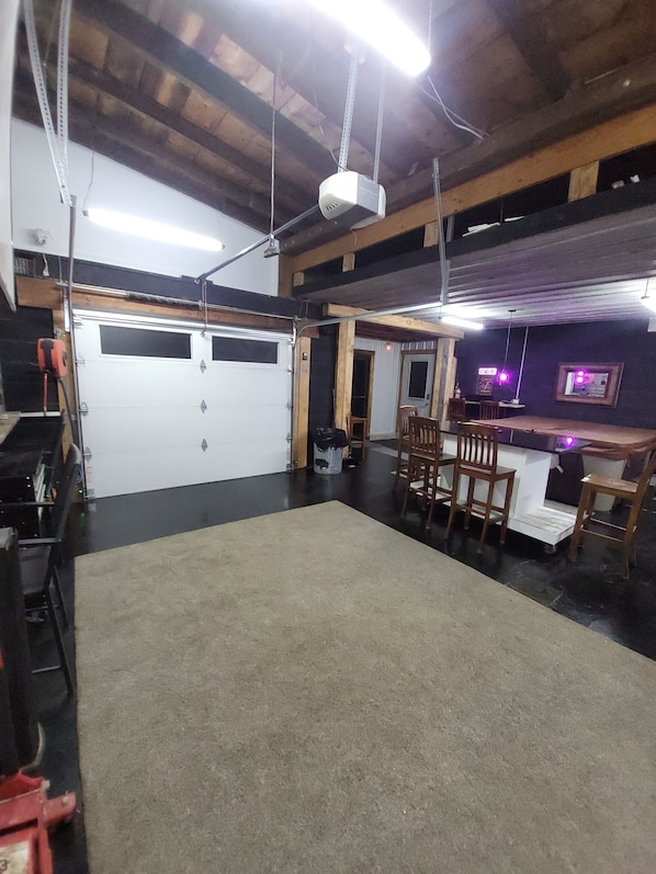A garage with a white door, a workbench, and a table with chairs.