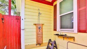 A yellow building with a wooden ladder, a metal handrail, and a window with red shutters. - Spacious Home with Bikes, Near Historic Downtown (St. Augustine)