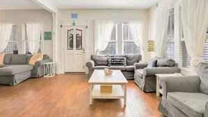 A living room with a sofa set, a coffee table, and a door with a glass panel. - Spacious Home with Bikes, Near Historic Downtown (St. Augustine)