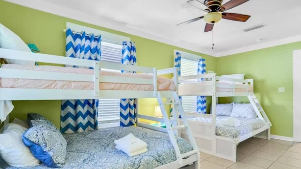 A room with bunk beds, a ceiling fan, and chevron-patterned curtains. - Spacious Home with Bikes, Near Historic Downtown (St. Augustine)