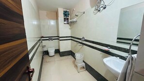 A bathroom with a toilet, bidet, sink, and a mirror. - Hotel Ram Janki Palace (Pindra)