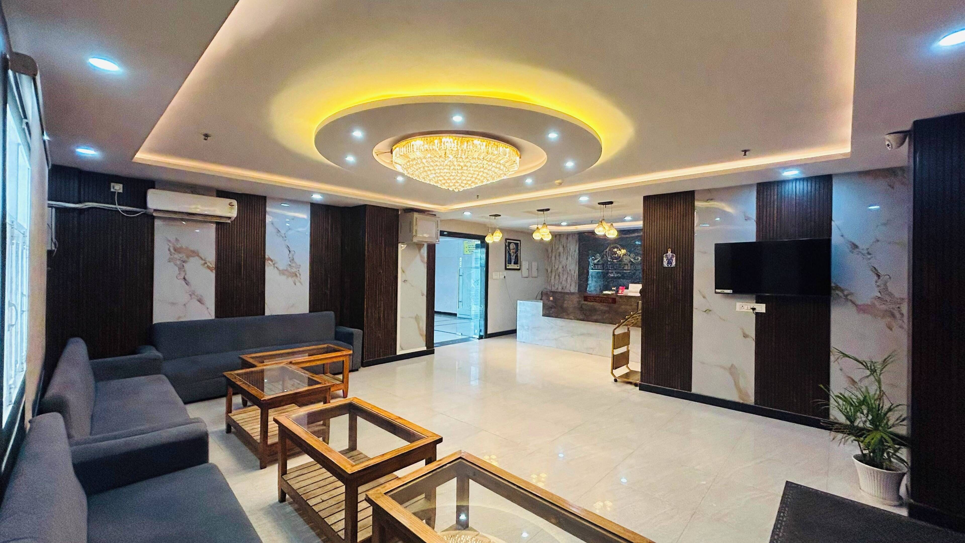 Una hall d'hotel con reception, area salotto e lampadario.