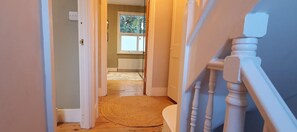 Enter a serene space with a window offering natural views, featuring a comfortable room with a radiator and a bathroom.
