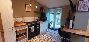 A kitchen with a gas stove, oven, and a tiled floor. - Cosy & Stylish Stay in Vibrant East Ham (Greater London)