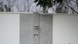 A concrete pathway leading to a door with a small window and a doorbell. - Aika House - A haven of peace in the heart of Michamvi  (Michamvi Kae.)