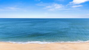 A beach with clear blue water and a sandy shore. - Oceanfront Condo with Stunning Views, Balcony, & Steps to the Beach! (Ocean City)