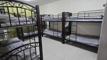 Un dormitorio con literas dispuestas en dos filas.