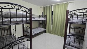 A room with bunk beds, a curtain, and a door. - Olaando (Abu Dhabi)