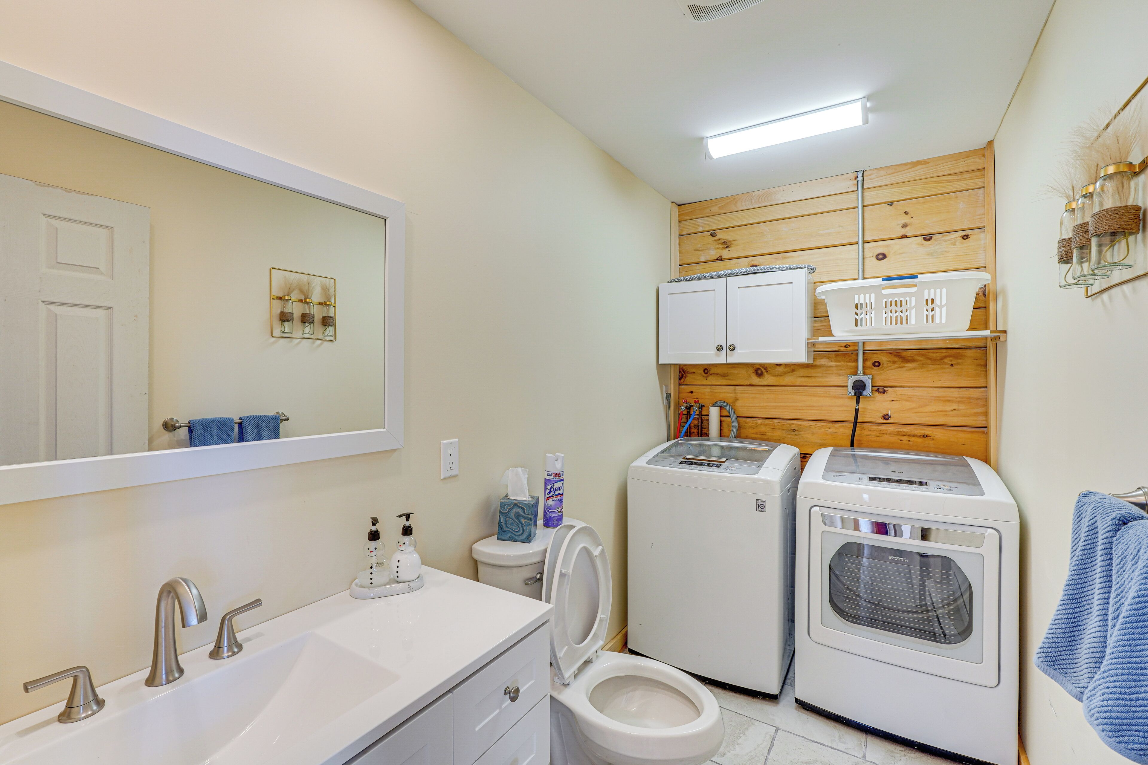 Un bagno piccolo ma funzionale, con lavandino, specchio, WC e due asciugacapelli.