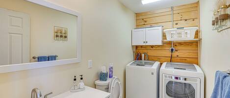 Un bagno piccolo ma funzionale, con lavandino, specchio, WC e due asciugacapelli.
