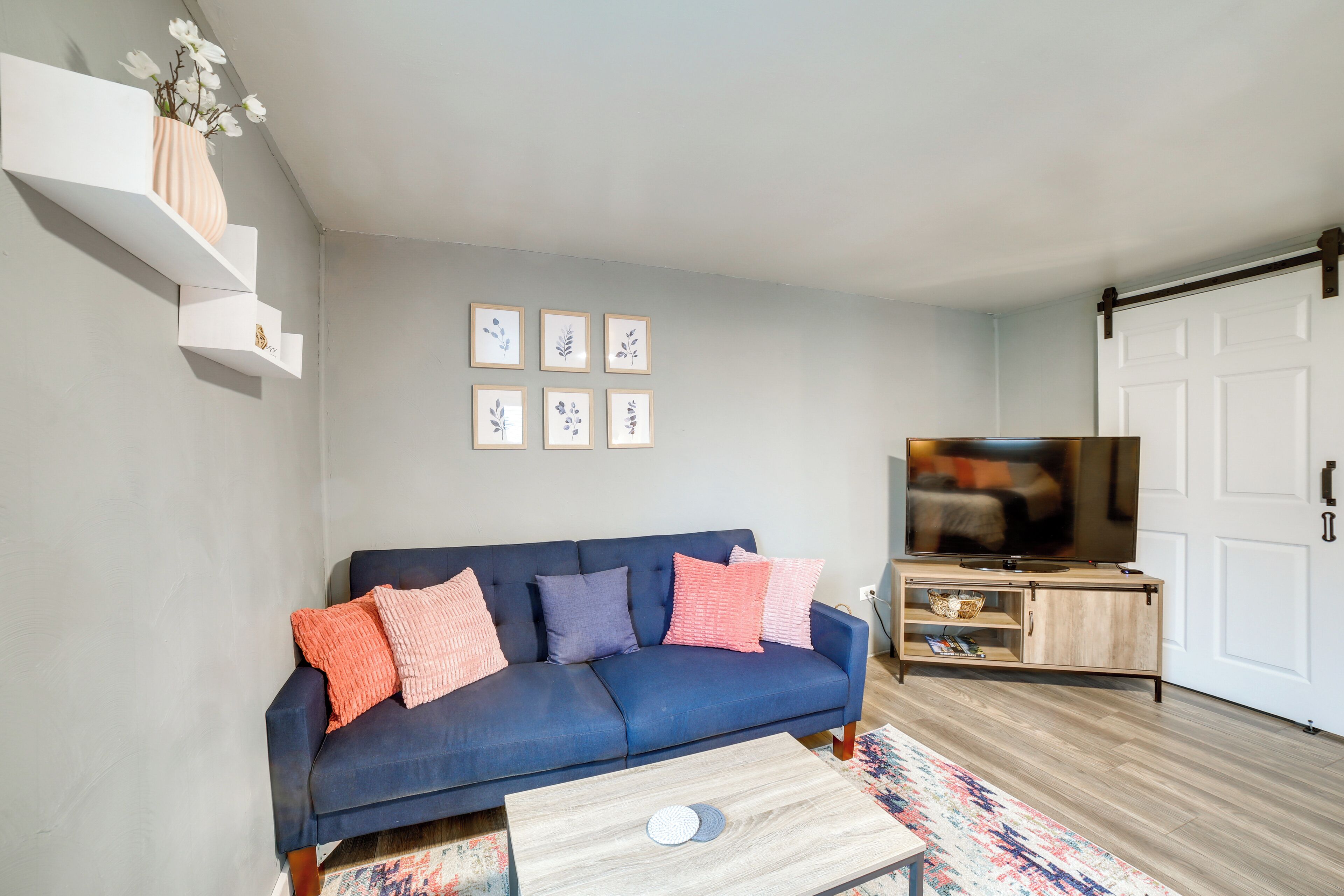 A living room with a blue sofa, a coffee table, a TV, and a bookshelf.