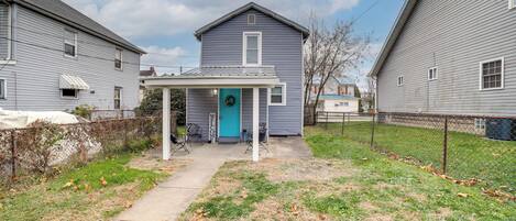 A house with a porch, a blue door, and a wreath.