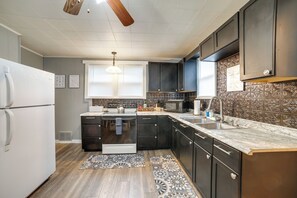 A modern kitchen with dark cabinets, a white refrigerator, a microwave, and a sink. - 2 Mi to Saint Vincent College: Home in Latrobe (Latrobe)