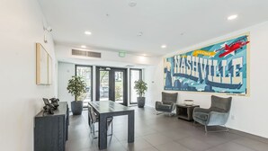 A modern lobby with a reception desk, seating area, and a large mural of Nashville.