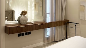 A modern bedroom with a large mirror, a wooden bedside table, a bed, and a window with sheer curtains. - Kease Narjis A-12 Luxury Gold AX18 (Riyadh)
