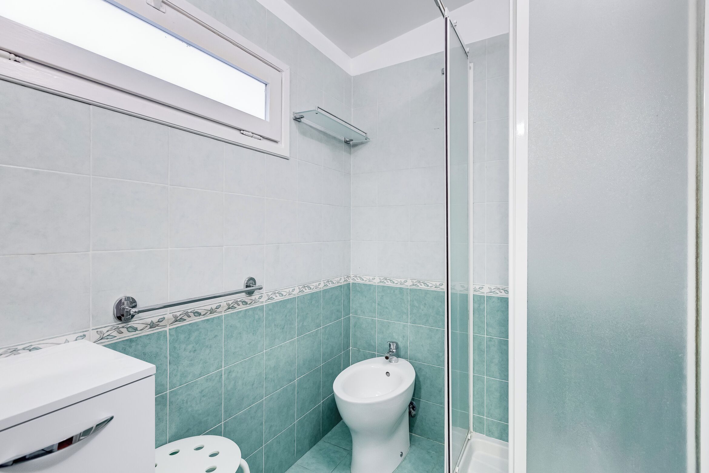 A bathroom with a toilet, bidet, and shower.