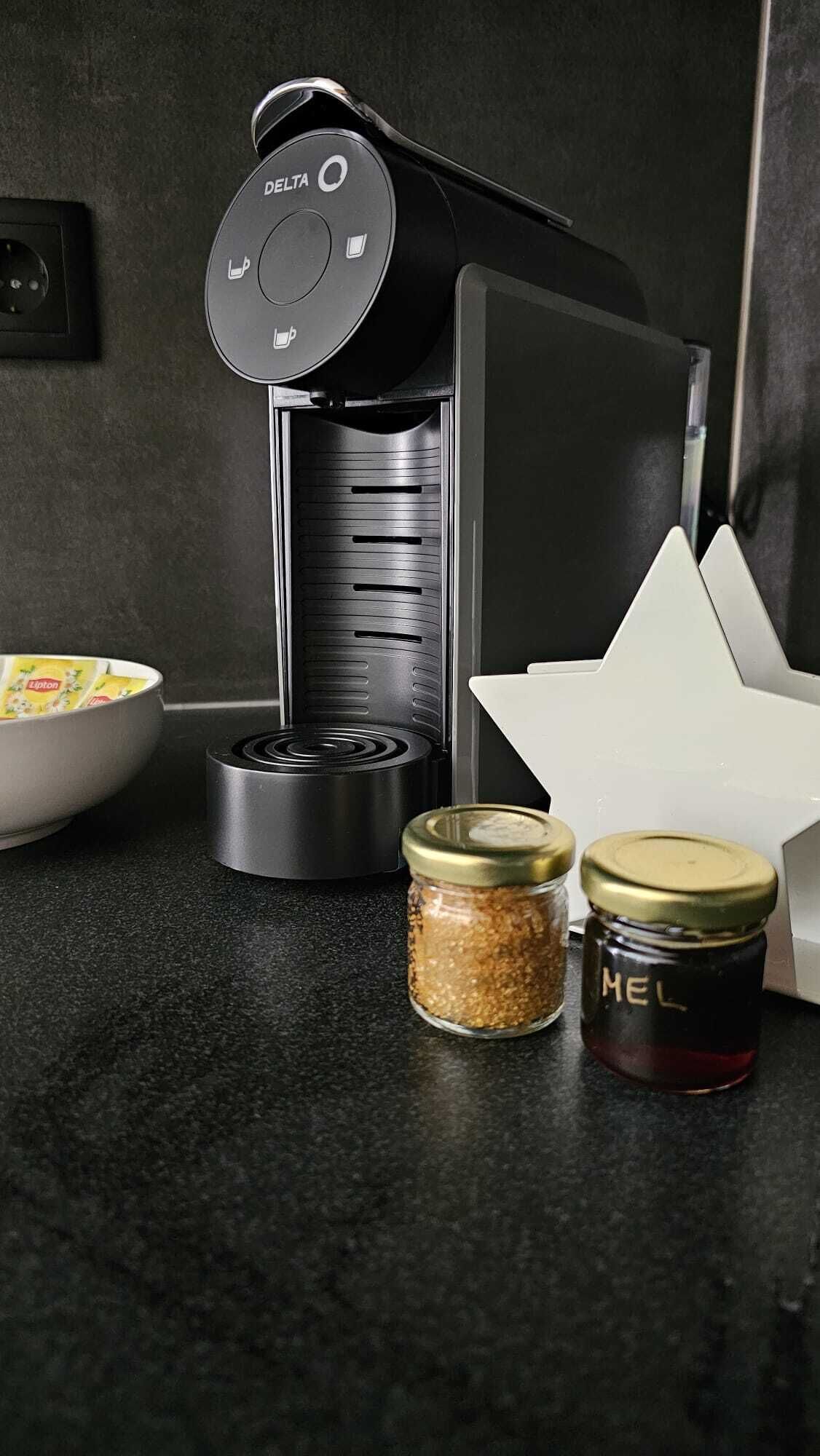 Eine Küche mit einer Kaffeemaschine, einer Schüssel Müsli und zwei Gewürzgläsern.