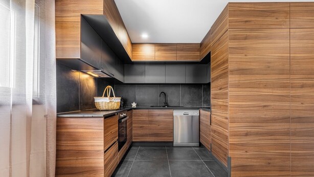 Une cuisine moderne avec des meubles en bois, un four encastré et un lave-vaisselle.