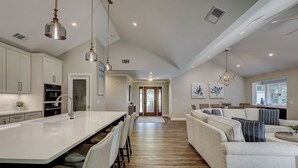 A modern kitchen with a central island, built-in appliances, and pendant lighting.