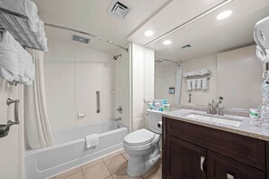 A modern bathroom with a bathtub, toilet, and sink. - Sun, Sand & a Rainy Day Backup (Virginia Beach)