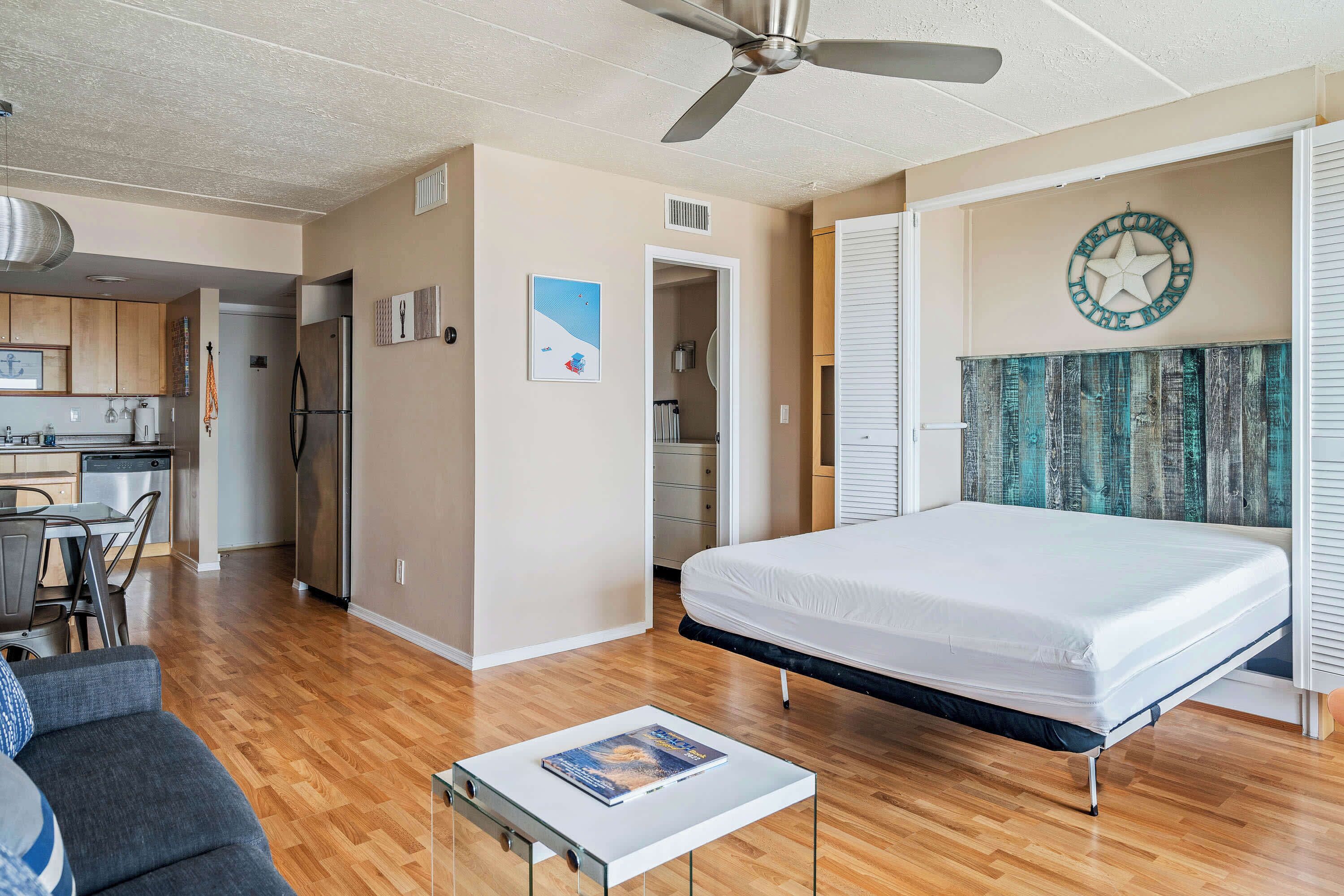 Un espace de vie compact comprenant un lit, une kitchenette et un coin repas.