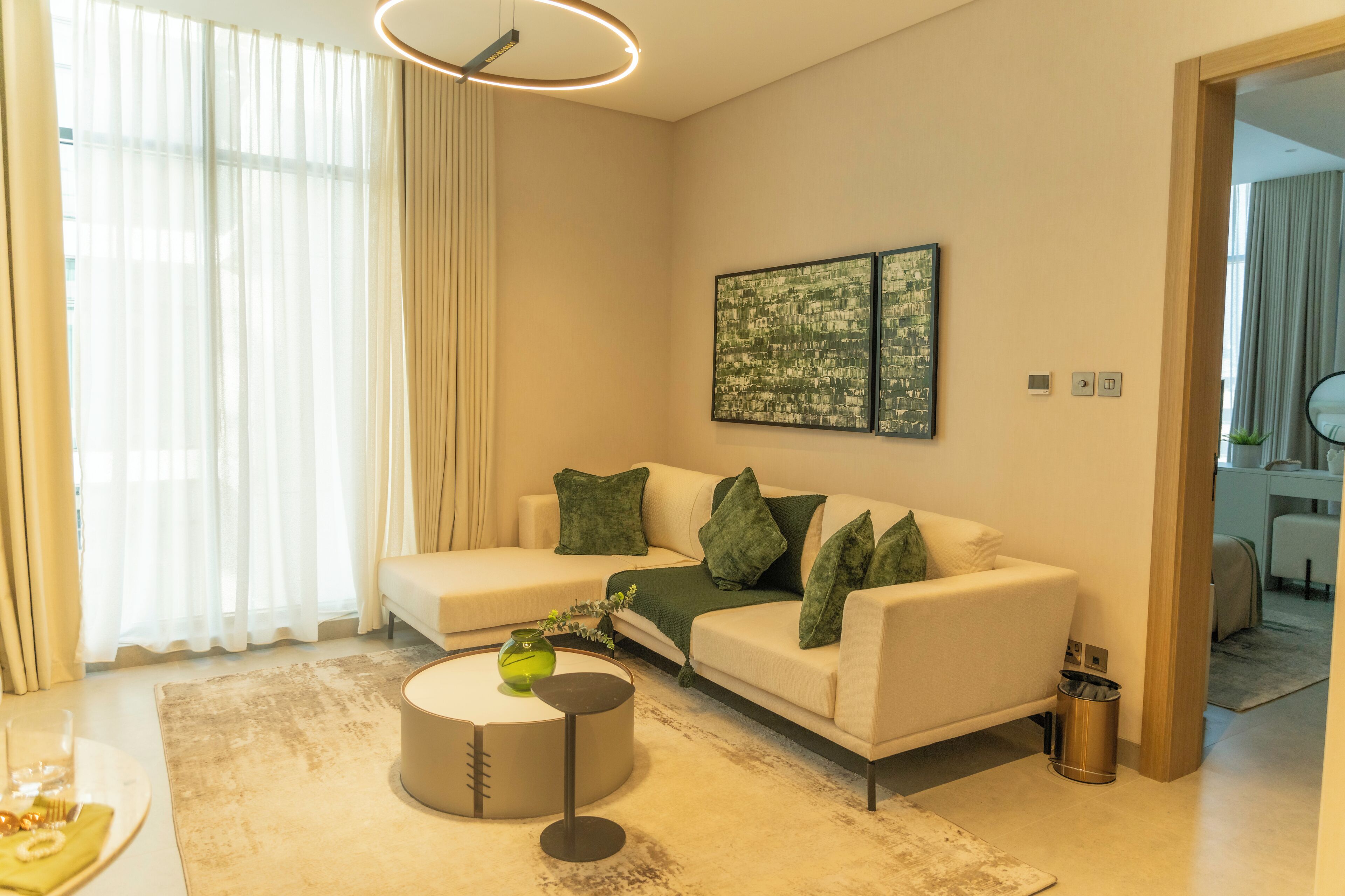 A modern living room with a sofa, a coffee table, and a painting on the wall.