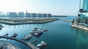 A marina with boats docked, a waterfront promenade, and high-rise buildings in the background. - Pearlhouse Bahrain (Manama)