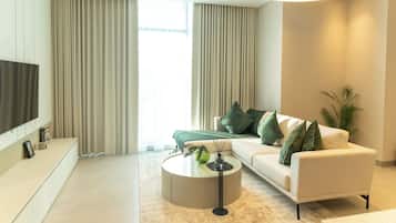 A modern living room with a sofa, a coffee table, and a TV mounted on the wall.