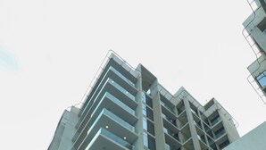 A modern building with multiple floors, large windows, and a staircase leading to the entrance. - Pearlhouse Bahrain (Manama)