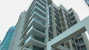 Stunning multi-story building with clean lines and a minimalist design, featuring a glass facade and spacious balconies.