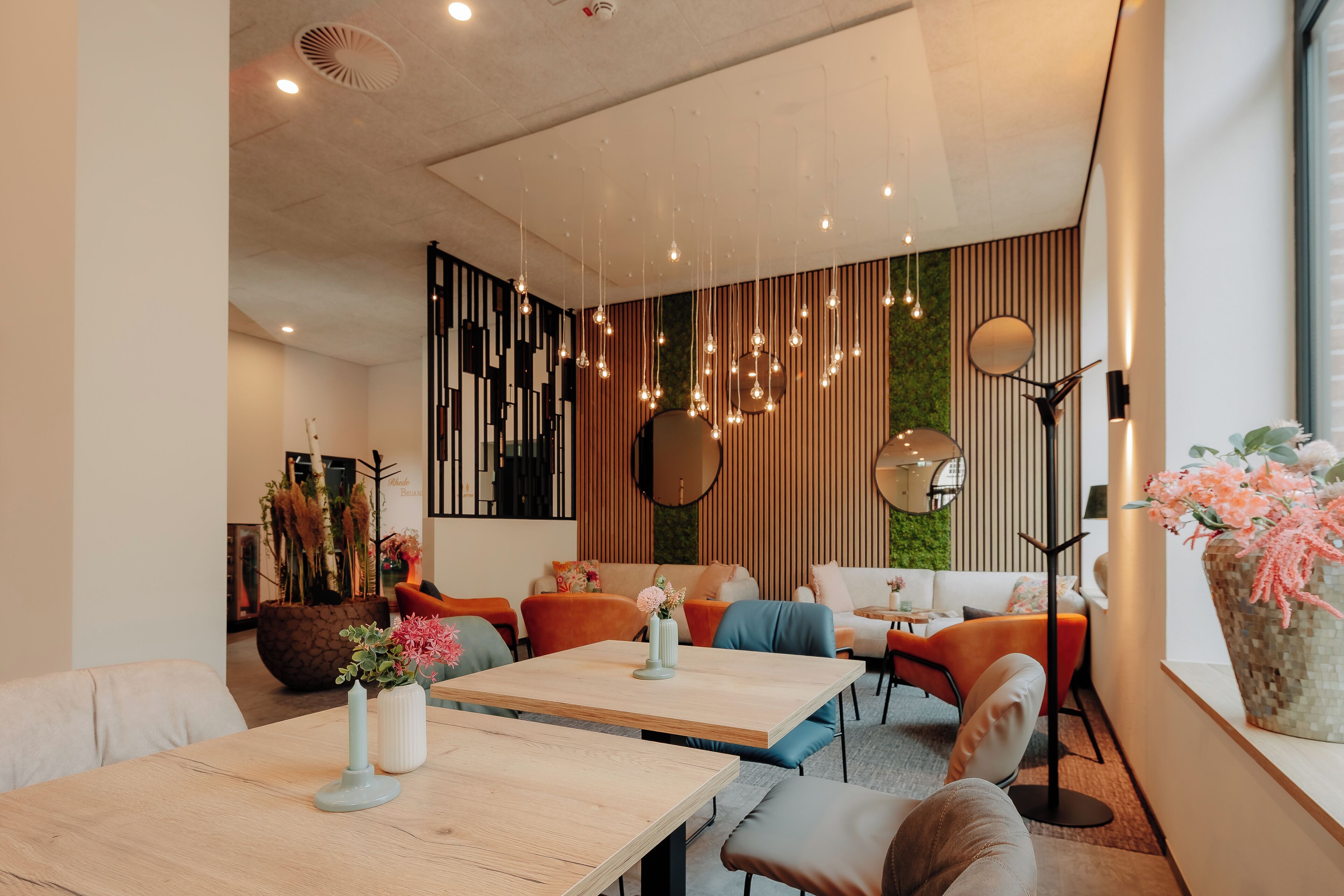 Un interior moderno con una mesa de comedor de madera, un sofá y una planta grande en maceta.
