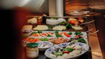 Une table de buffet proposant divers plats, notamment des fruits de mer, des salades et du pain.