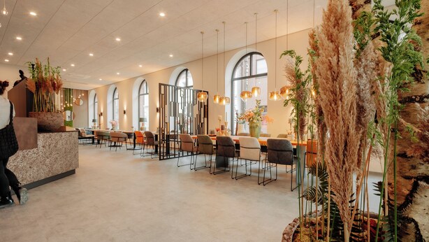 A spacious hotel lobby with a long reception desk, multiple seating areas, and large windows. - Stadthöfe Rhede by Hackmann (Rhede)