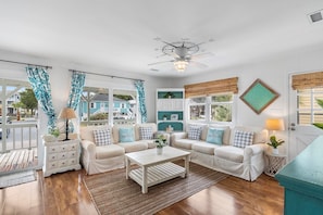 A living room with a white ceiling fan, a wooden coffee table, and a sofa set.