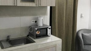 A compact kitchenette with a microwave, a kettle, and a sink. - Comfort with elevator: complimentary breakfast buffet  (Dakar)