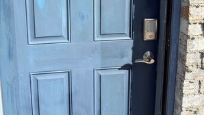 Une porte bleu foncé ornée d’un « G » doré, dotée d’un clavier pour l’ouverture et d’une poignée de porte.