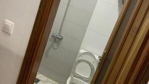 A bathroom with a toilet, a shower, and a hand dryer. - Comfort studio with elevator: complimentary breakfast buffet  (Dakar)