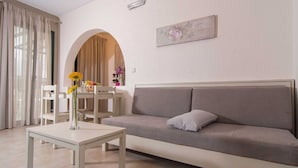 Una sala de estar con sofá, una mesa de centro y un comedor con sillas y mesa.