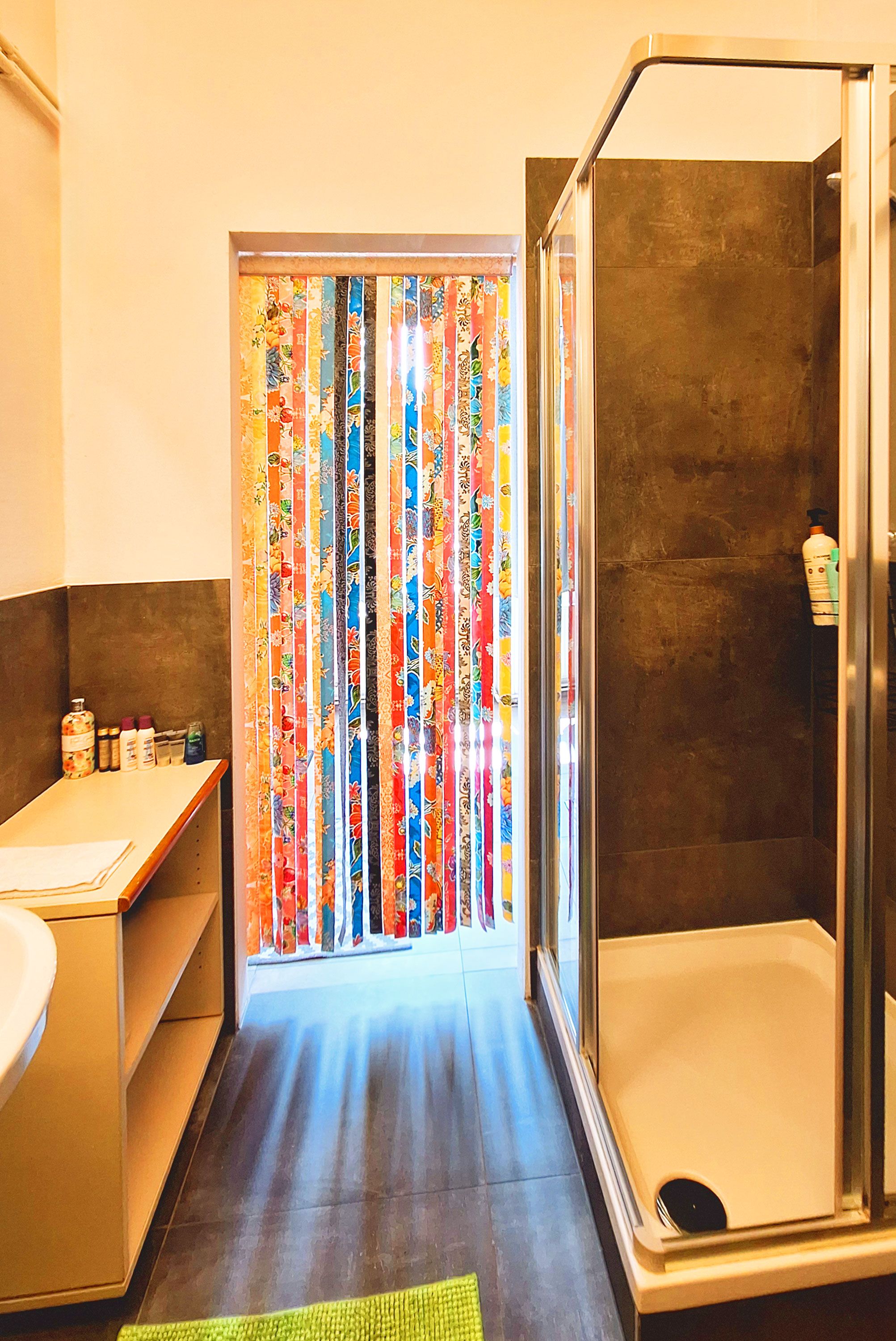 Een badkamer met een douche, toilet en wastafel.