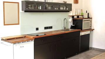 Apartamento, vistas al patio | Cocina privada | Frigorífico grande, microondas, horno y placa de cocina