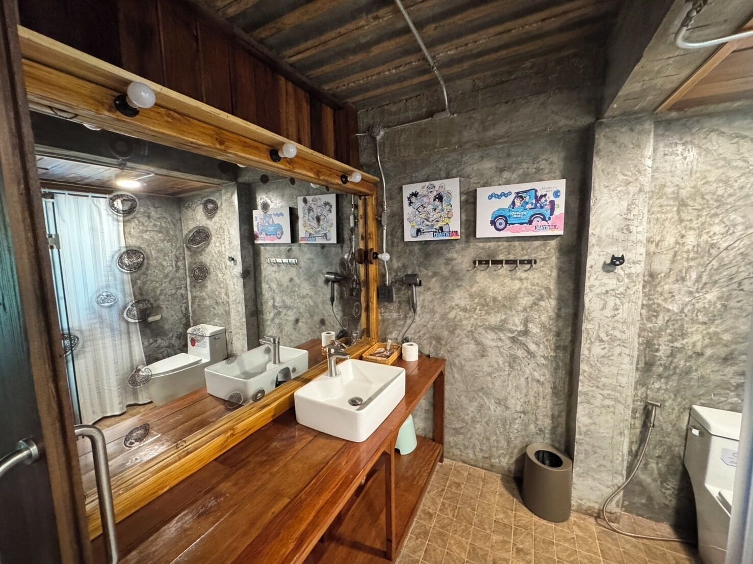 A bathroom with a wooden vanity, a large mirror, and a shower area.