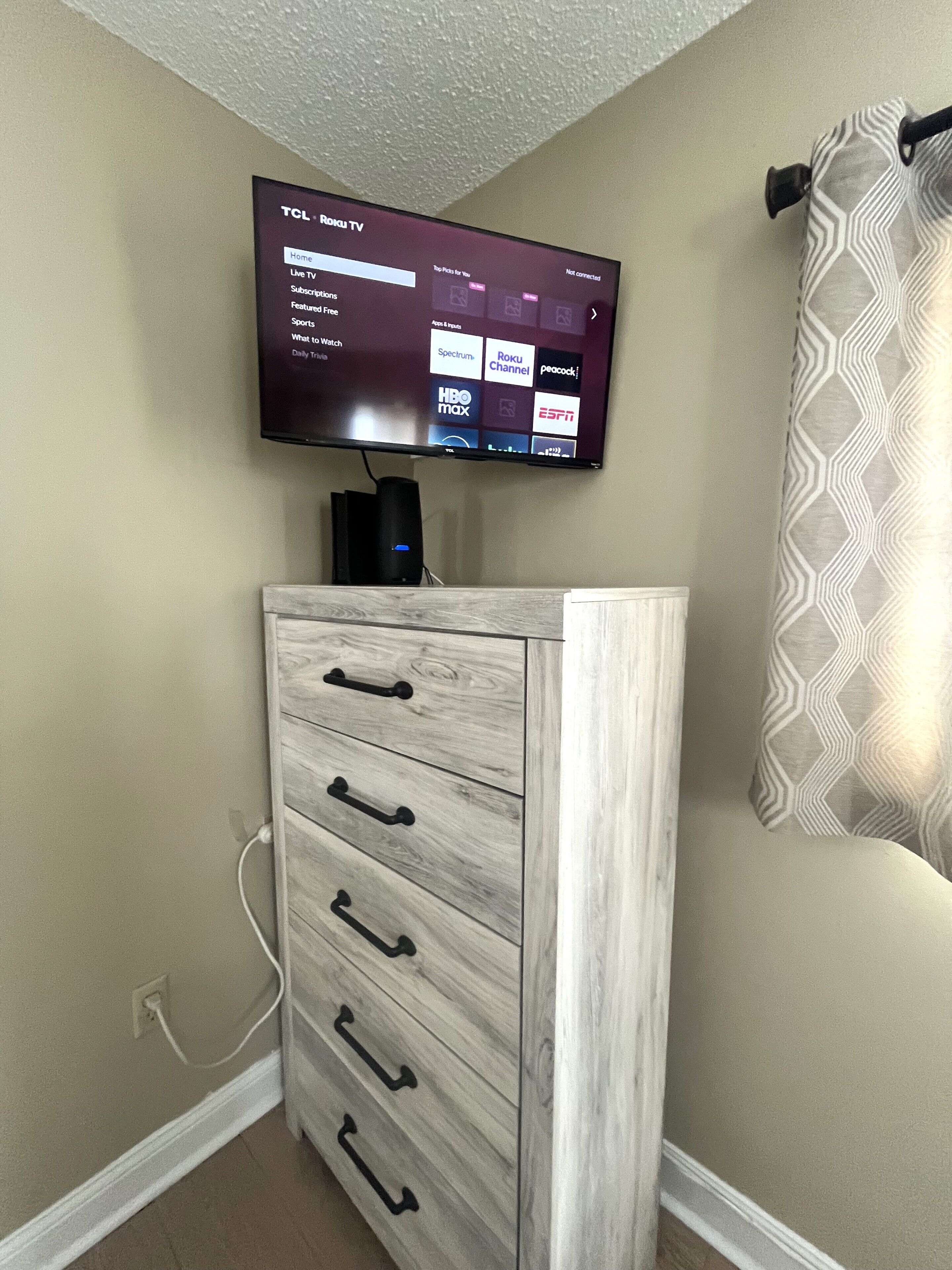 A flat-screen TV mounted on a wall displaying a streaming service interface.