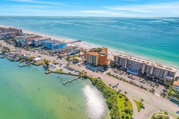 Vista aérea de una zona hotelera costera con edificios, un puerto deportivo y una playa.